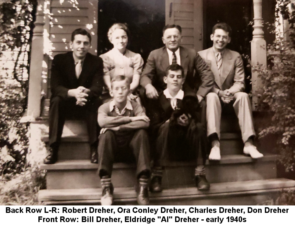 Black and white photo of Robert Dreher, Ora Conley Dreher, Charles Dreher, Don Dreher, Bill Dreher, and Eldridge 'Al' Dreher sitting on the broad front steps of a frame house surrounded by leafy foliage, in the early 1940s.